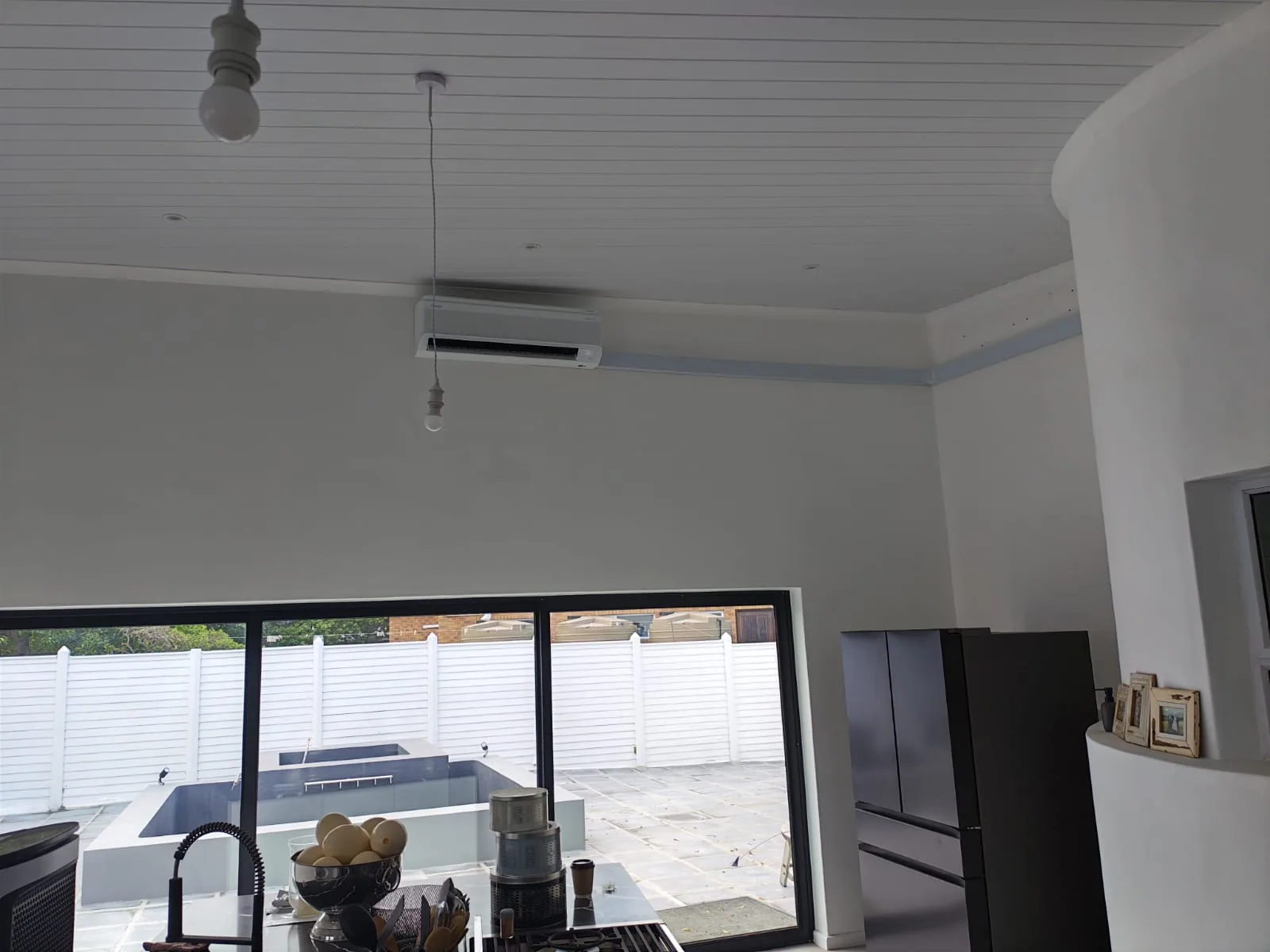 Wall-mounted split air-conditioning unit installed above a glazed doorway.