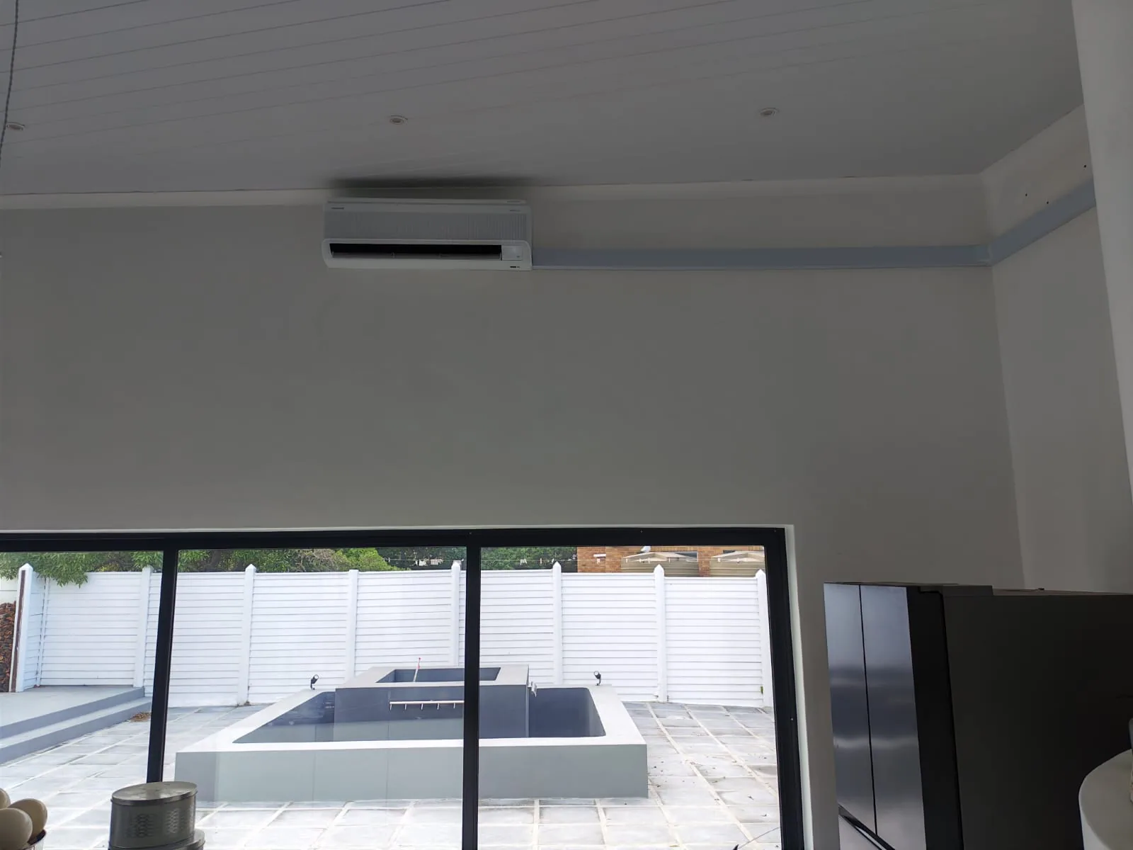 Wall-mounted split air-conditioning unit installed in an open-plan kitchen.