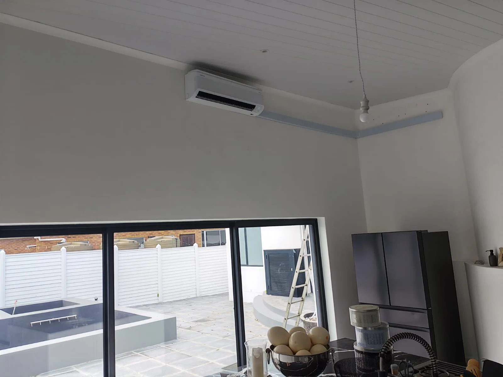 Split air-conditioning unit positioned high on a curved interior wall.