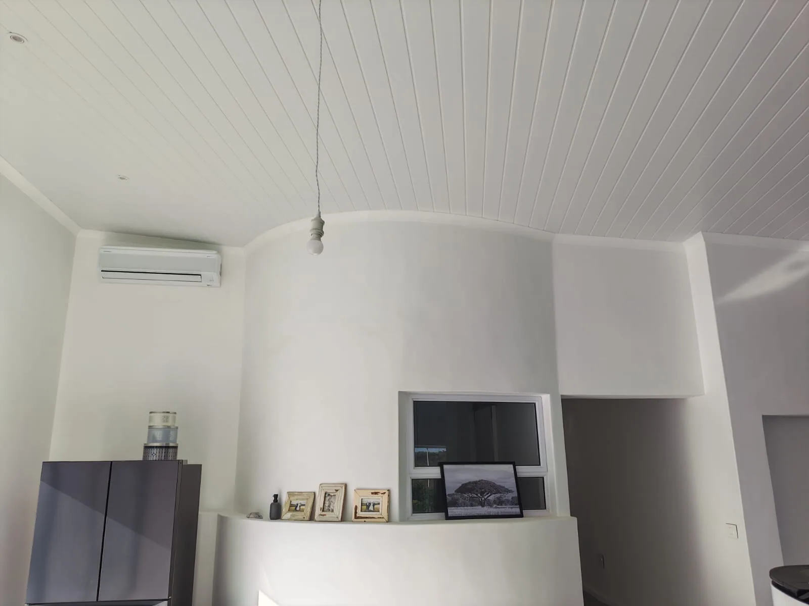 Indoor split air-conditioning unit positioned near a curved ceiling.