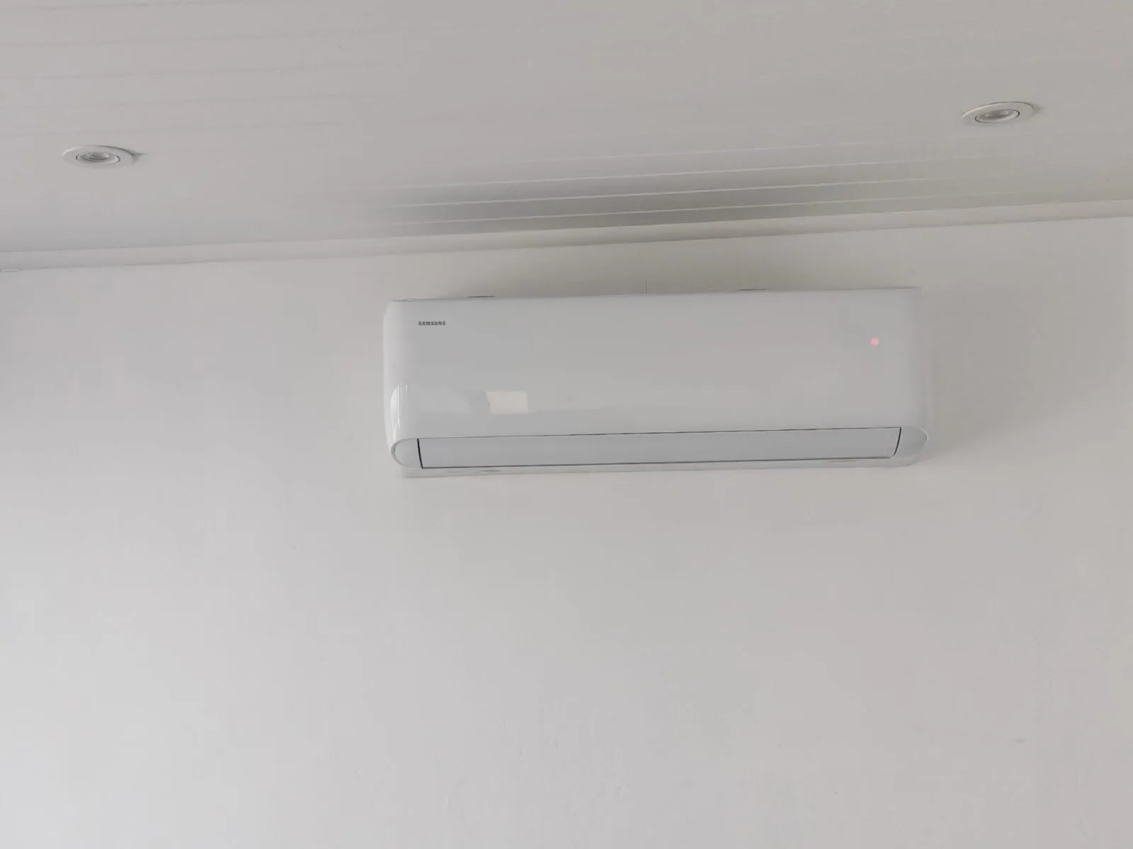 Indoor split air-conditioning unit installed high on a plain wall.