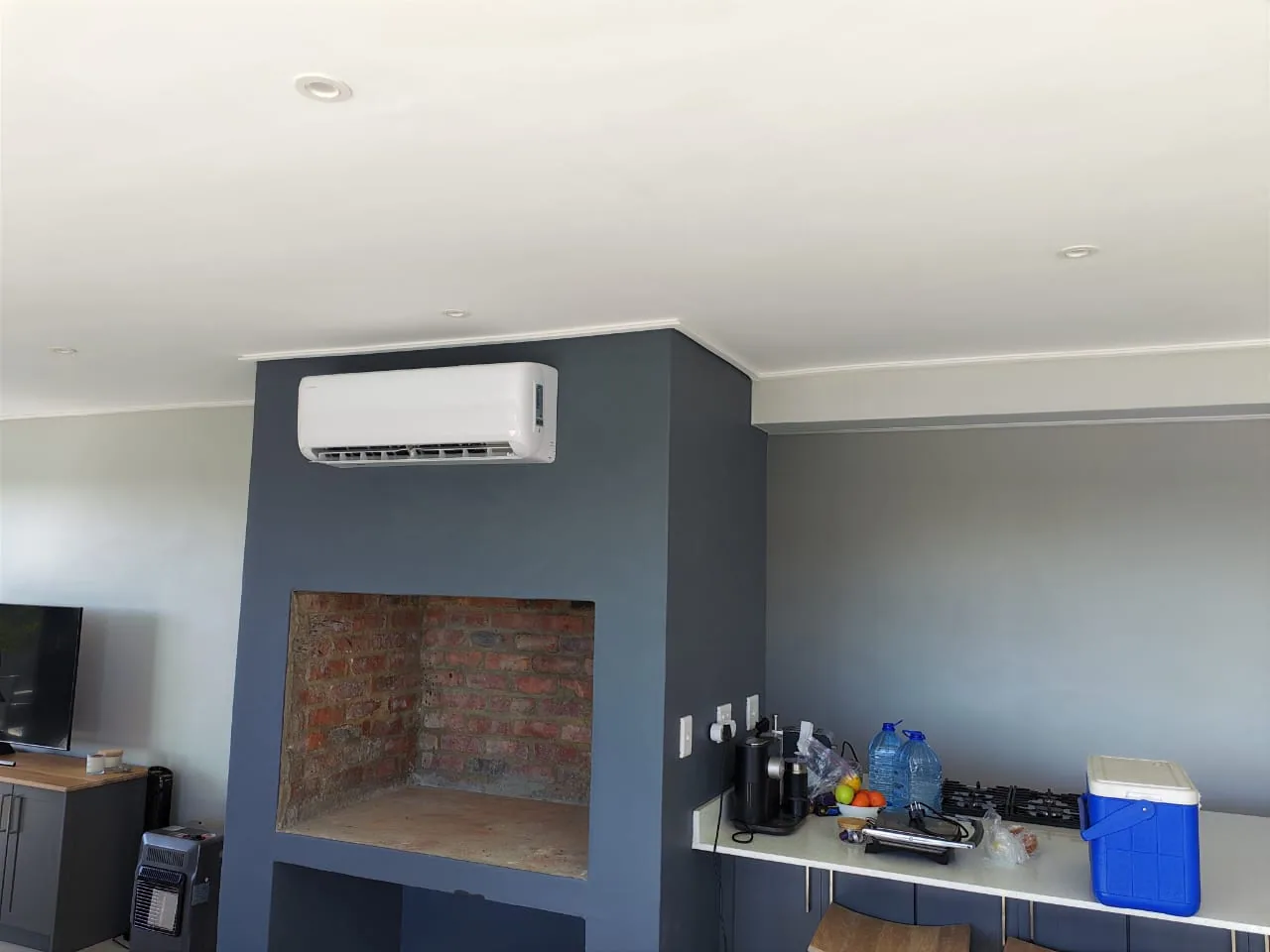 Interior view of an air-conditioning unit above a fireplace feature wall.